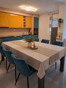 a kitchen with a table with blue cabinets at Apartman Tea in Pićan