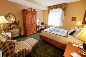 a hotel room with a large bed and a desk at The Mimslyn Inn in Luray +18 photos