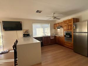 a kitchen with a stainless steel refrigerator and wooden cabinets at Private Rm3A in Elderslie in Elderslie