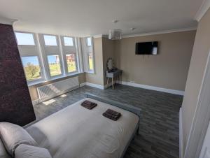 a living room with a white bed and a tv at Bar 21 in Hunstanton