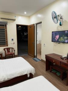 a bedroom with a bed and a tv and a desk at Khách sạn Nậm Rốm in Diện Biên Phủ
