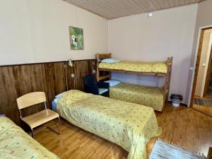 a room with three bunk beds and a chair at Majatalo Tyrni in Nakkila