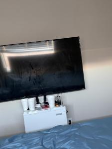 a flat screen tv above a bed in a room at EdCccc life in Las Vegas