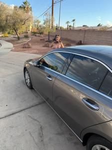a woman is standing next to a car at EdCccc life in Las Vegas