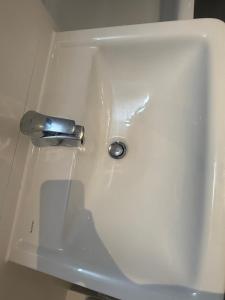 a white sink with a silver faucet on it at Home Away From Home in Schönefeld