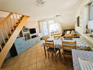 a living room with a table and chairs and a staircase at Schulstrasse 10a Fewo in Zingst