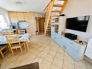 a kitchen and dining room with a television and a table at Schulstrasse 10a Fewo in Zingst +3 photos