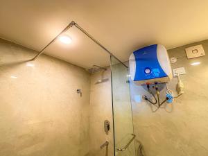 a shower with a blue machine in a bathroom at Hotel Old Bellevue Heritage Stay with Mountain Views in Chowrasta Darjeeling in Darjeeling +75 photos