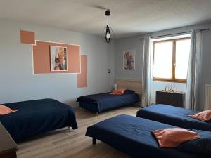 a room with three beds and a window at La Grande Ferme in Arinthod