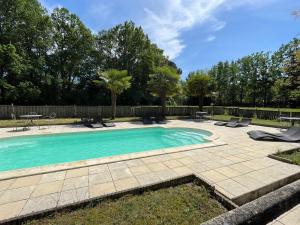 a swimming pool in a yard with chairs and a fence at Château De La Coutancière in Brain-sur-Allonnes