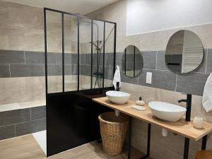 a bathroom with two sinks and two mirrors at La Grande Ferme in Arinthod