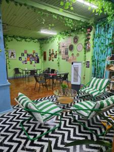 a room with green walls with chairs and tables at city mountain hotle in Vang Vieng +47 photos