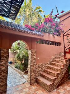 a house with a brick staircase with flowers on it at LOUIZA HOUSE, vue imprenable entre lac et désert in Lalla Takerkoust