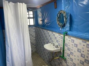a blue bathroom with a sink and a mirror at SaitotiMara Safaris in Sekenani