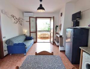 a living room with a blue couch and a refrigerator at Casa Oscar in Catabbio