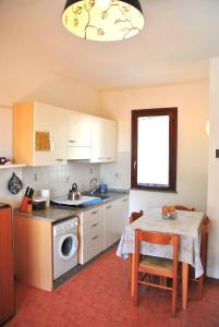 a kitchen with a table and a sink and a washing machine at Casa Oscar in Catabbio