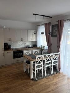 a kitchen with a dining room table and chairs at Odskocznia2 in Maniowy