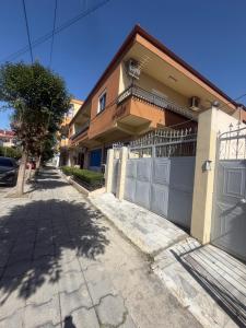 a house with a fence and a garage at Valentina Cozy 2-Bedroom House in Lushnjë