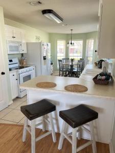 a kitchen with a large white island with two stools at La SeaEsta in Navarre