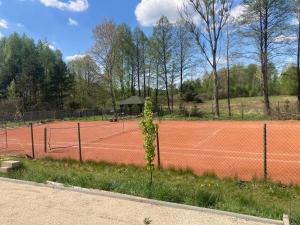 a tennis court with a net and a gazebo at Słoneczny Set in Wólka Klucka