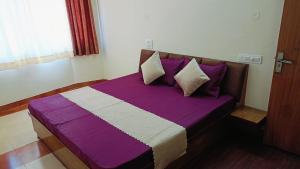 a purple and white bed in a room at Hotel Atithyam in Solan +9 photos