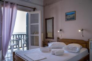 a bedroom with a bed with a view of the ocean at Remezzo Guesthouse in Agios Ioannis Pelio