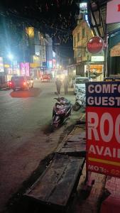 a motorcycle parked on the side of a street at night at Hotel Atithyam in Solan