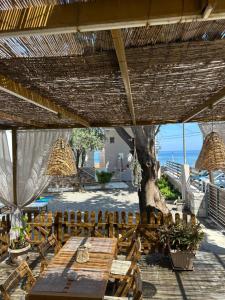 a patio with a table and chairs and a tree at Mika's Paradise in Archangelos