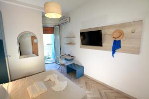 a living room with a table and a tv on a wall at Art Hotel La Perla in Bellaria-Igea Marina