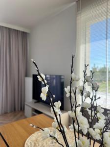 a vase filled with white flowers on a table at Pino SeaView I in Gdańsk