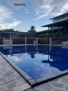 a swimming pool in front of a fence at Pousada Aruanã in Soure