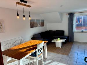 a living room with a table and a couch at Ferienwohnungen Matschak OG rechts in Fehmarn