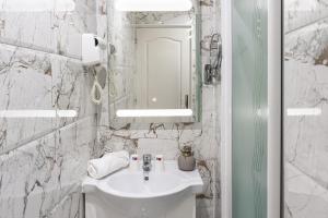 a white bathroom with a sink and a mirror at HOTEL ROYAL Paris Ivry in Ivry-sur-Seine +145 photos