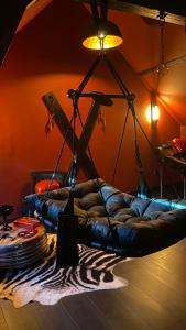 a living room with a couch with a light on it at Love Room SPA l'impertinente in Isbergues