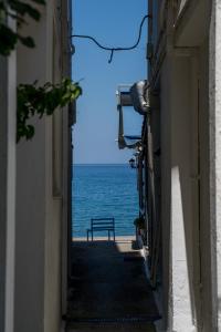 a view of the ocean from between two buildings at Remezzo Guesthouse in Agios Ioannis Pelio