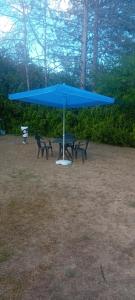 a table and chairs under a blue umbrella at Vila Sofija in Vinci