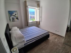 a small bedroom with a bed with a window at Bilocale nuovissimo! A due passi dal mare! in Levanto