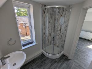 a bathroom with a shower and a sink and a window at Bar 21 in Hunstanton +54 photos