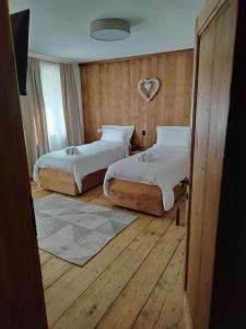 a bedroom with two beds and a heart on the wall at La Casa dei Ricordi in Igne