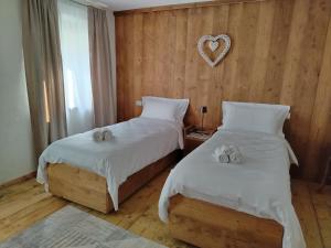two beds in a room with a heart on the wall at La Casa dei Ricordi in Igne