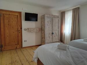a bedroom with two beds and a tv on the wall at La Casa dei Ricordi in Igne