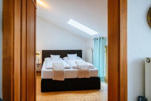 a bedroom with a bed with white sheets and pillows at Ferienwohnung Chiemgau in Eggstätt