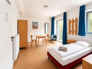 a bedroom with a bed and a table and chairs at Hindenburg-Dependance Hotel Krone in Bad Gastein