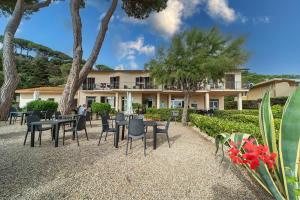 a resort with tables and chairs in front of a building at Hotel Voce del Mare in Capoliveri