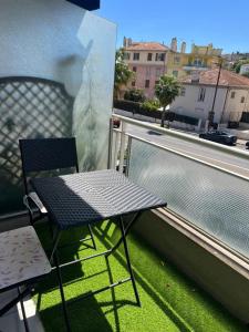a chair and a table on a balcony with a view at Chambre d'hôte Cannes in Le Cannet +8 photos