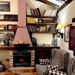 a living room with two chairs and a fireplace at La Tejera de Fausto in Requijada