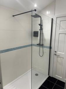 a shower with a glass door in a bathroom at Double Bedroom with Private Entrance in Weymouth