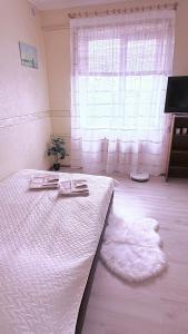 a bedroom with a white bed and a window at Uuemõisa apart in Haapsalu