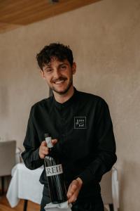 a man is holding a bottle of wine at Hotel Krondlhof in Brunico +94 photos