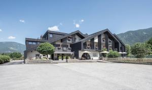 a large black building with mountains in the background at Hotel Krondlhof in Brunico